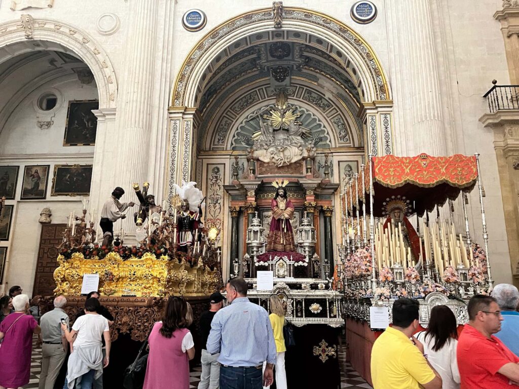 Personnes admirant un paso installé dans la Cathédrale de Grenade